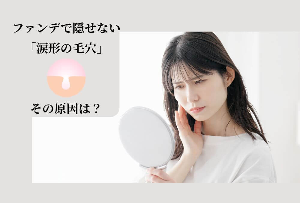 鏡に映る自分の頬のたるみ毛穴を、心配そうな表情で気にしている40代女性。