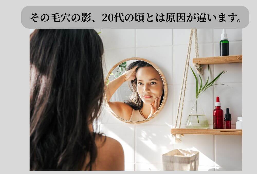 鏡を見て頬の開き毛穴を気にする40代女性。