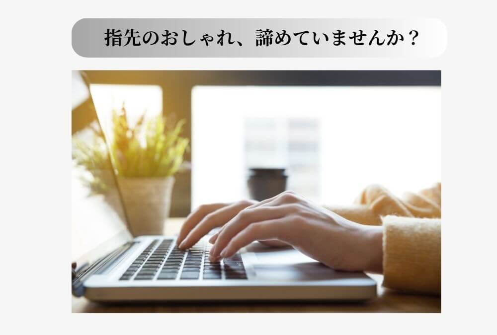 オフィスでパソコンのキーボードに置かれた、ネイルをしていない40代女性の手元