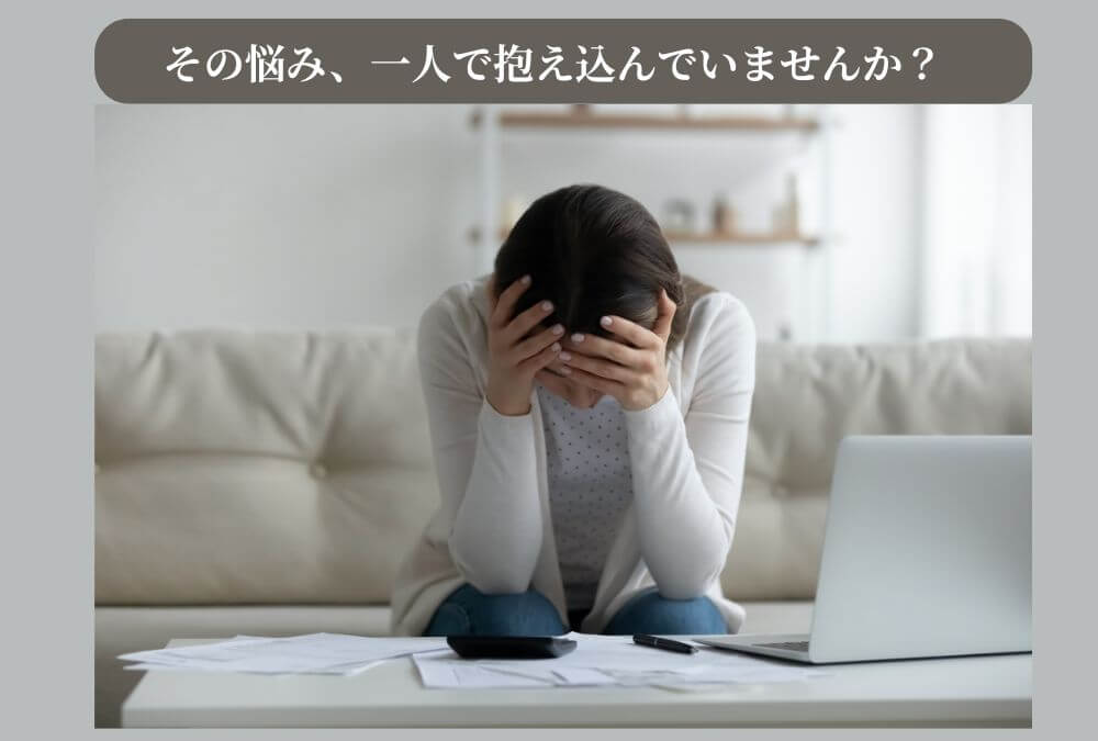 40代の漠然とした不安を表現した画像。頭を両手で抱えて、悩んでいる女性の様子。